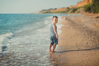 Güzel bir kumsal üzerinde çalışan çocuk. Güzel bir sahilde yürüyüş çocuk. Deniz köpüğü kum üzerinde. yaşam tarzı ilişki iletişim safkan soy