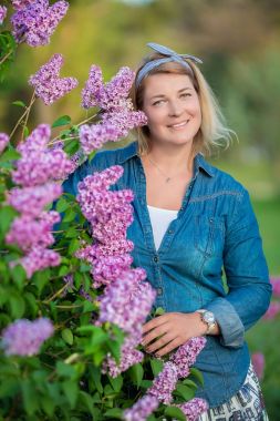 Güzel bir kadınla leylak grup ve genç hamile anne bahar bahçe, portre, çiçek çelenk