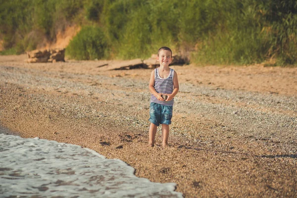 Хлопчик біжить на прекрасному пляжі. Хлопчик гуляє на прекрасному пляжі. Морська піна на піску. стосунки способу життя контакт родовідного походження — стокове фото