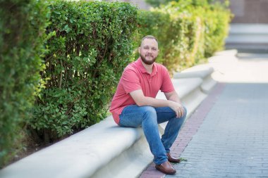 Kot ve beyaz t-shirt eski duvara yaslanmış yakışıklı bir genç adam portresi.