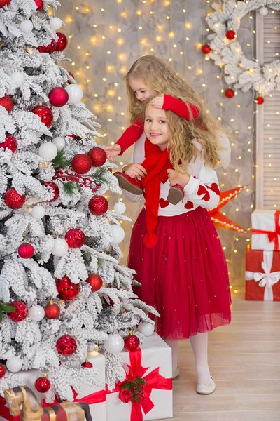 Kerst portret van twee beautyful leuke meisjes Smiling zusters vrienden en luxe groen witte kerstboom in unieke interieur studio met enorme gouden spiegel en bont — Stockfoto