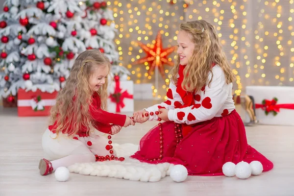 Χριστούγεννα πορτρέτο του όμορφο δύο χαριτωμένα κορίτσια Smiling αδελφές φίλοι και Χριστούγεννα Πολυτελές Πράσινο λευκό δέντρο στο μοναδικό εσωτερικό στούντιο με τεράστιο χρυσό καθρέφτη και γούνα — Φωτογραφία Αρχείου