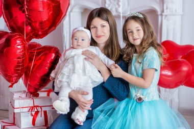 güzel genç anne ve kızı elbiseler ile çelenk üzerinde renkli baloons fotoğraf Studio ile onların hads