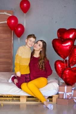 Güzel şirin genç esmer anne anne ile her diğer ve mutlu bir arada tutan genç yakışıklı oğlu. Kadın sarı kalemler ve kırmızı tatlı.