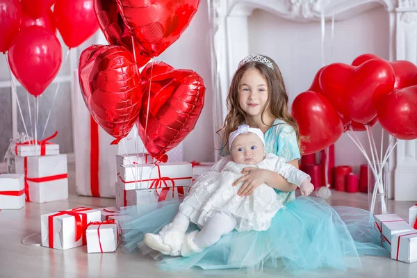 Söt baby flicka firar födelse dag tillsammans nära röda ballonger. Härlig scen av baby på soffa divan med presenter och röda baloons. — Stockfoto