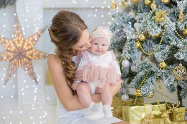 Anne biraz tatlı ve güzel kızı ile geçirdiği zaman çalış, Noel ağacı yanında oturan coos