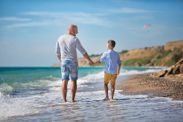 Padre e figlio che giocano sulla spiaggia a tempo di giorno. concetto di famiglia amichevole. — Zdjęcie stockowe