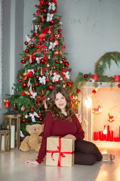 Feiertage, Feiern und Menschen Konzept - junge Frau in elegantem Kleid über Weihnachten Interieur Hintergrund. Bild mit Korn — Stockfoto
