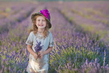 Genç güzel kız harika elbise ve şapka bir hafta sonu gün lavanta sahada yürüyüş.