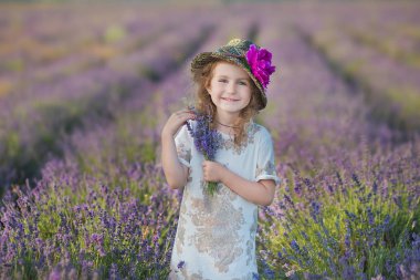 Genç güzel kız harika elbise ve şapka bir hafta sonu gün lavanta sahada yürüyüş.