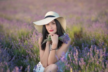 Lovely yüz lavanta sahada bir hafta sonu gün harika elbise ve şapka üzerinde yürüyen genç güzel bayanla.