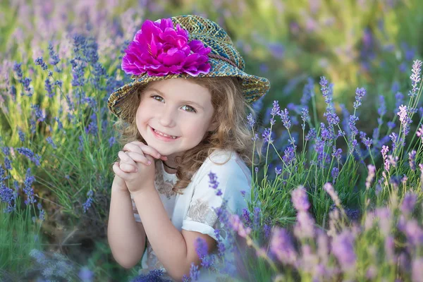 Menina bonita jovem andando no campo de lavanda em um dia de fim de semana em vestidos e chapéus maravilhosos . — Fotografia de Stock