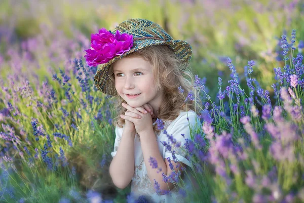 Молодая красивая девушка ходит по лавандовому полю в выходной день в чудесных платьях и шляпах . — стоковое фото