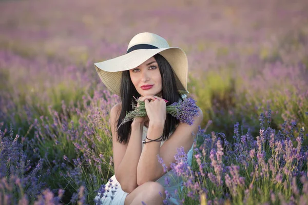 Tânăra doamnă frumoasă cu fața frumoasă mergând pe câmpul de lavandă într-o zi de weekend în rochii și pălării minunate . — Fotografie, imagine de stoc