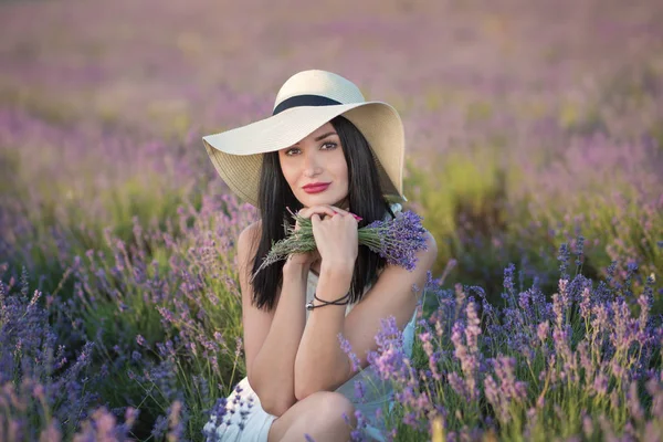 Jeune belle dame avec beau visage marchant sur le champ de lavande un week-end dans de magnifiques robes et chapeaux . — Photo