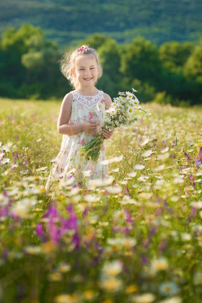 Mamma och dotter på picknick i fältet kamomill. Två vackra blondiner i kamomill fält på en bakgrund av häst. Mor och dotter omfamnar i fältet kamomill — Stockfoto