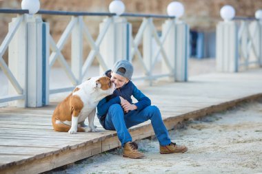 Güzel görünümlü yakışıklı çocuk bulldog ile sahilde