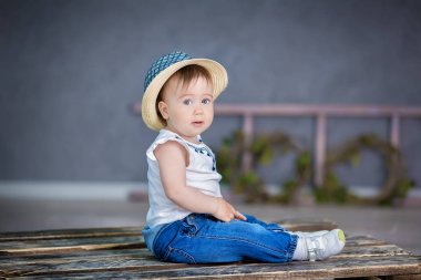 Öğe, dikey, açık renkli bir şirin bebek kız kanepe sepet üzerinde oturan başında çiçek çelenk
