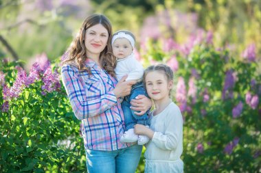 mutlu anne ve kızı ile çiçek açan leylaklar bahçede yeşil elma