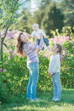mutlu anne ve kızı ile çiçek açan leylaklar bahçede yeşil elma