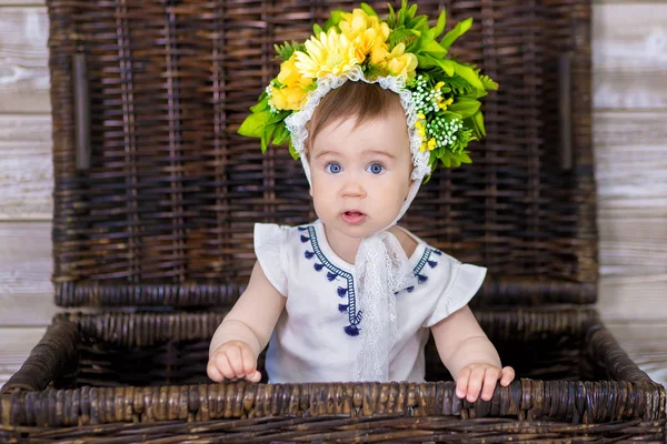 소파 바구니에 그녀의 머리에 꽃의 화 환으로 빛 바탕에 귀여운 딸의 초상화 — 스톡 사진