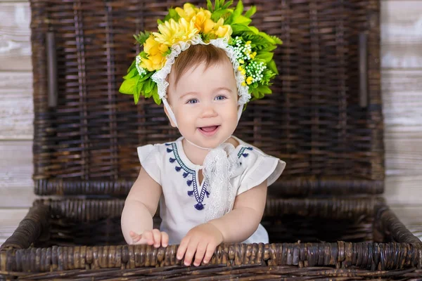 소파 바구니에 그녀의 머리에 꽃의 화 환으로 빛 바탕에 귀여운 딸의 초상화 — 스톡 사진