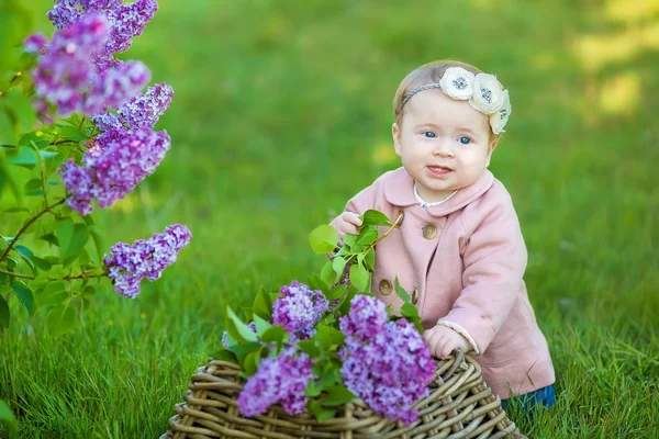 아기 소녀 1-2 년 된 입고 꽃 화 환, 야외 라일락의 꽃다발을 들고 웃 고. 카메라를 보고. 여름 봄 시간. — 스톡 사진