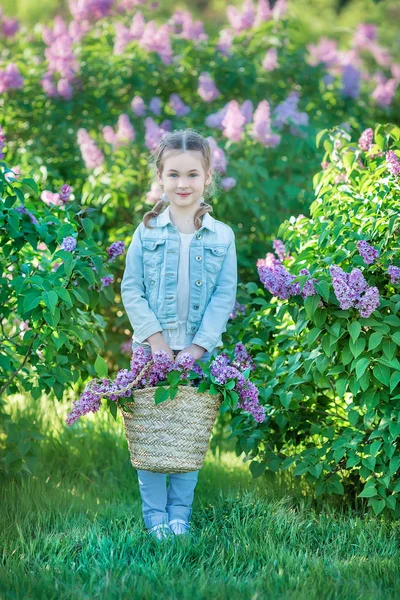 Mosolygós kislány aranyos szőke gyermek 4-9 évben egy-egy csokor a kezében a farmer és póló lila — Stock Fotó