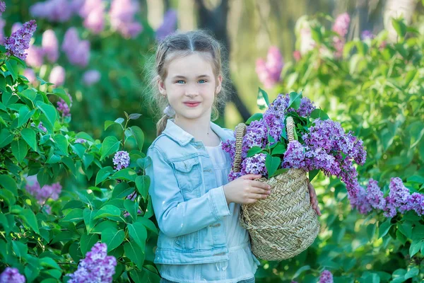 Mosolygós kislány aranyos szőke gyermek 4-9 évben egy-egy csokor a kezében a farmer és póló lila — Stock Fotó