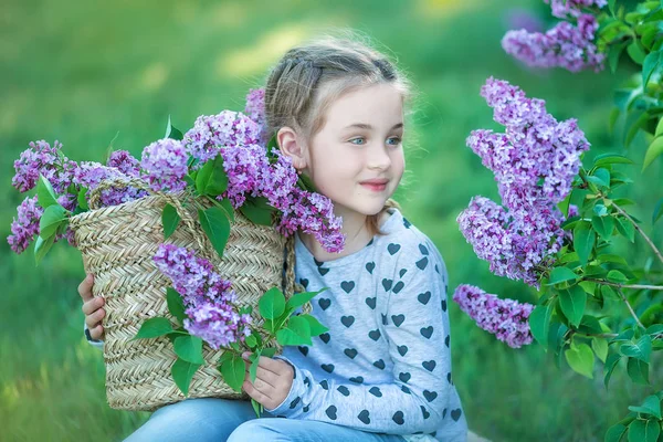 Mosolygós kislány aranyos szőke gyermek 4-9 évben egy-egy csokor a kezében a farmer és póló lila — Stock Fotó