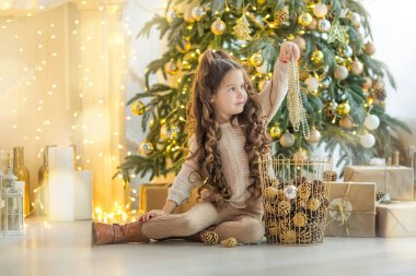 Çocuk Noel ağacı ve evde şömine yakın hediye kutusu ile küçük kız