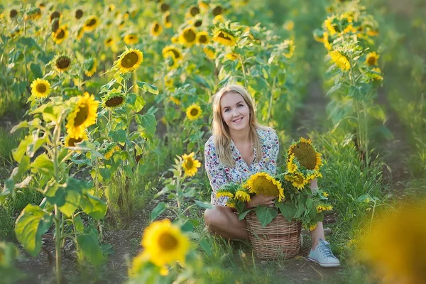Młoda kobieta z kwiatów słońce i w stylowy kapelusz i niebieskie dżinsy szorty moda — Zdjęcie stockowe