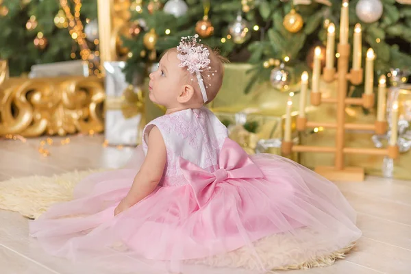 크리스마스 행복 한 재미 있는 아기 아이 스튜디오 장식 새 해 크리스마스 트리 주변 캐주얼의 자 소파에서 분홍색 드레스를 즐기고 — 스톡 사진