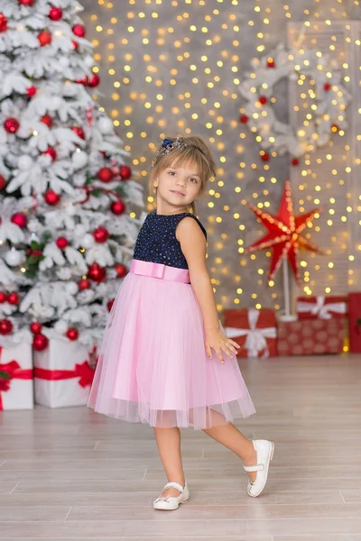Natal crianças engraçadas felizes menina desfrutando de estúdio de decoração do ano novo com presentes árvore espelho e sofá cadeira vestida com vestidos arejados casuais — Fotografia de Stock