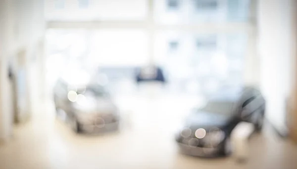 Tienda de concesionarios borrosa, con los coches y un rayo suave — Foto de Stock