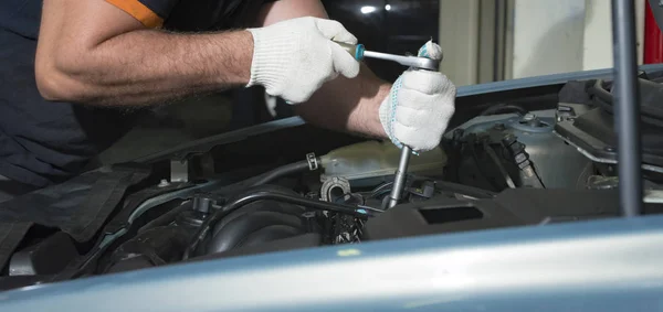 Mãos do mecânico do carro com uma chave inglesa, no serviço de reparação de automóveis . — Fotografia de Stock