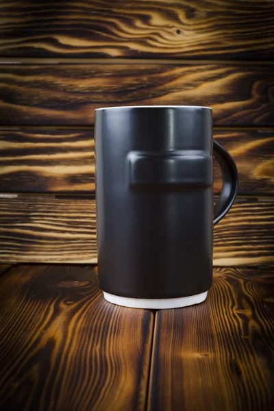 Taza de cerámica negra sobre fondo de madera — Foto de Stock