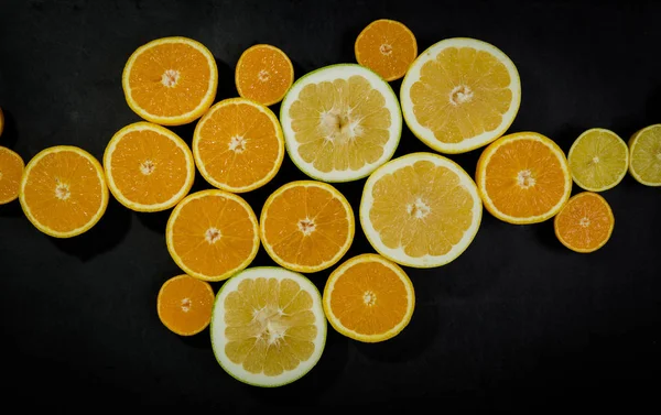 Citrus fruits (orange, lemon, grapefruit, mandarin, lime) on the dark background. Fruit food background. Fresh citrus fruit assortment