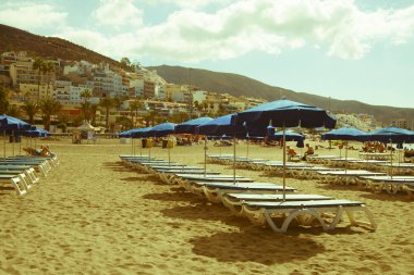 Şemsiyeli ve plaj yataklı tropikal boş kumsal manzarası