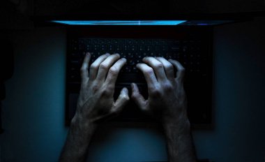 Dizüstü bilgisayarındaki bir programcının ellerinin üst görüntüsü.
