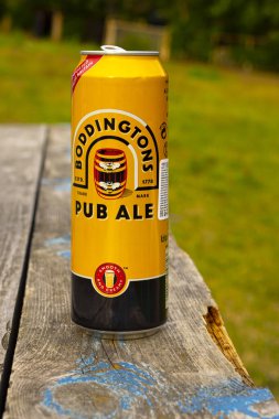 Arka bahçedeki bankta bir kutu Boddingtons Draught Bitter