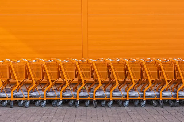 Girişte duran turuncu alışveriş arabası. — Stok fotoğraf