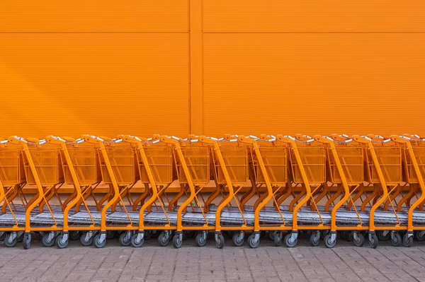 Carrello della spesa arancione impilato all'ingresso — Foto Stock