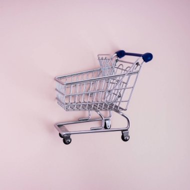 Pembe arka planda boş alışveriş arabası