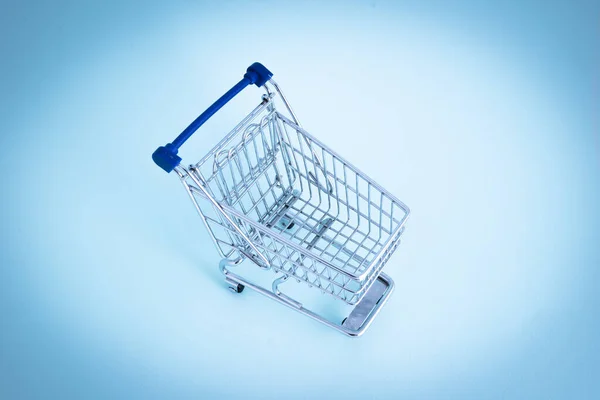 Carrito de compras vacío sobre fondo azul —  Fotos de Stock