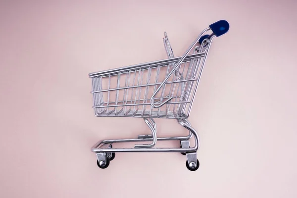 Carro de compras vacío sobre fondo rosa —  Fotos de Stock