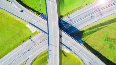 Şehirdeki otoyolun havadan görüntüsü. Arabalar üst geçitten geçiyor. Otoyol trafiği ile kesişir. Otobanın havadan çekilmiş kuş bakışı fotoğrafı. Çevre yolu. Yol ayrımları. Araba geçiyor. Yukarıdan üst görünüm.