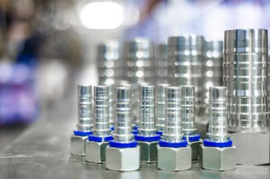 Metal hidrolik tesisatlar depodaki gümüş masanın üzerinde duruyor.