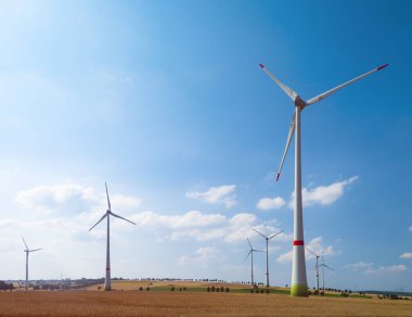 Eko güç. Rüzgar türbinleri elektrik üretiyor. Bir yaz gününde rüzgar türbinleri ve tarım alanları - Temiz ve Yenilenebilir Enerji ile Enerji Üretimi