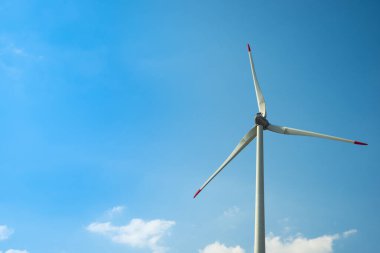 Eko güç. Rüzgar türbini elektrik üretiyor. Yaz günü mavi gökyüzünde rüzgar türbini - Temiz ve yenilenebilir enerjili enerji üretimi